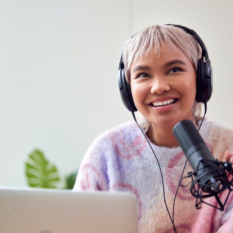 woman-recording-podcast-or-broadcasting-on-radio-in-studio-at-home-with-laptop.jpg